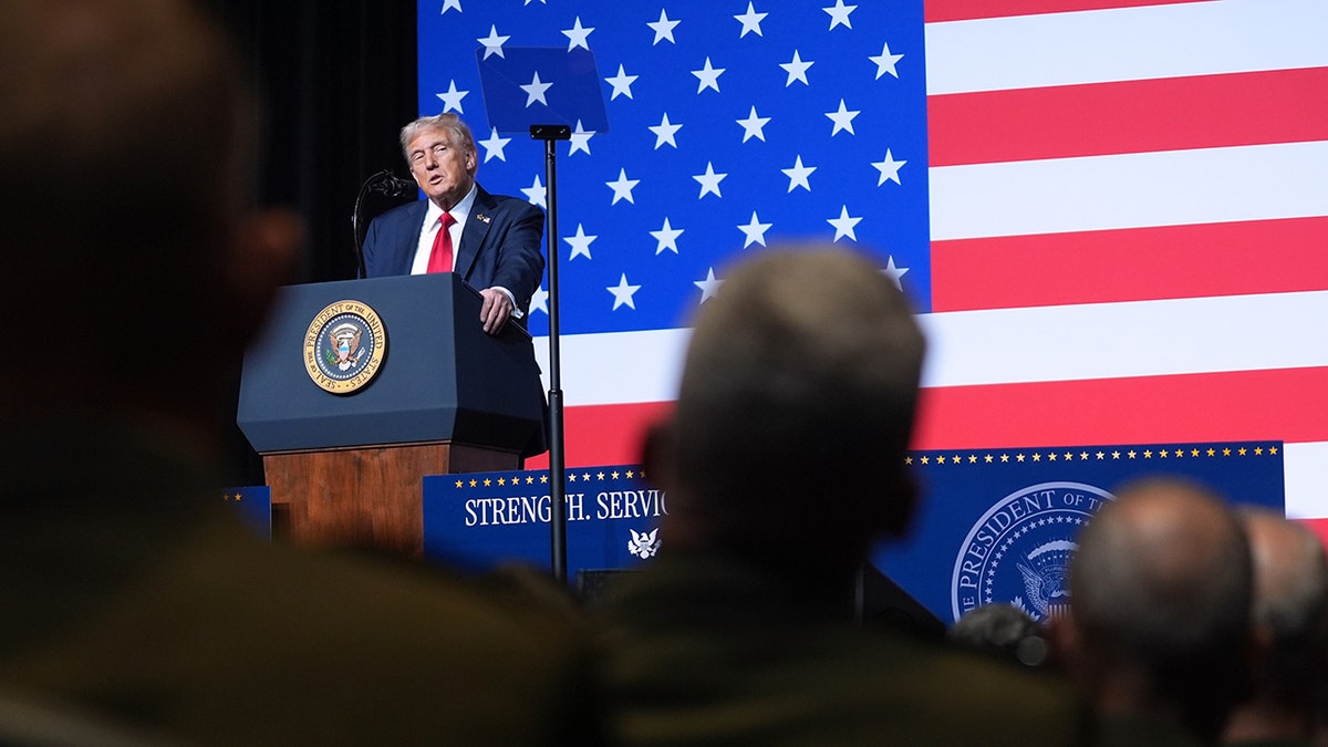 Donald Trump speaking to military senior leaders with American flag backdrop