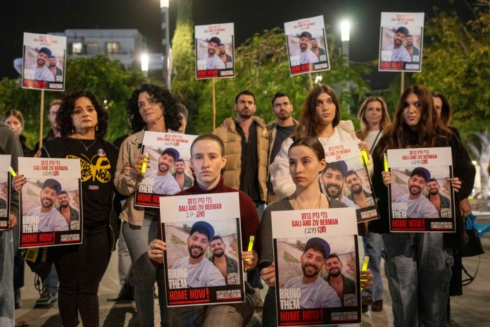 Supporters, some twins, and the family members of twin brothers, Ziv and Gali Berman, who are held by Hamas in Gaza, gathered in Tel Aviv, Israel to call for their release , Thursday, Dec. 26, 2024. (AP Photo/Ohad Zwigenberg)