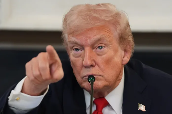 President Donald Trump points during a roundtable meeting.