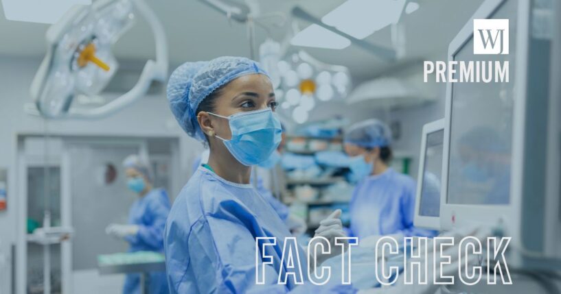 An anesthetist wears protective gear while checking monitors and sedating a patient before a procedure.