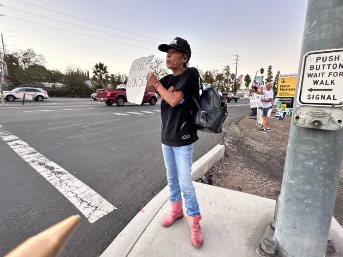 Maria Garcia holds a "No to Prop 50" sign at the corner of Citracado Parkway and Escondido Boulevard in Escondido, California on Thursday, Oct. 30, 2025. (Barnini Chakraborty/Washington Examiner)