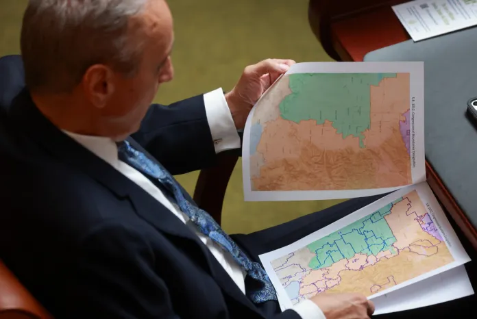 Rep. Cory Maloy, R-Lehi, holds a packet of potential redistricting maps as SB1012 Congressional Boundaries Designation is discussed in the House chamber.