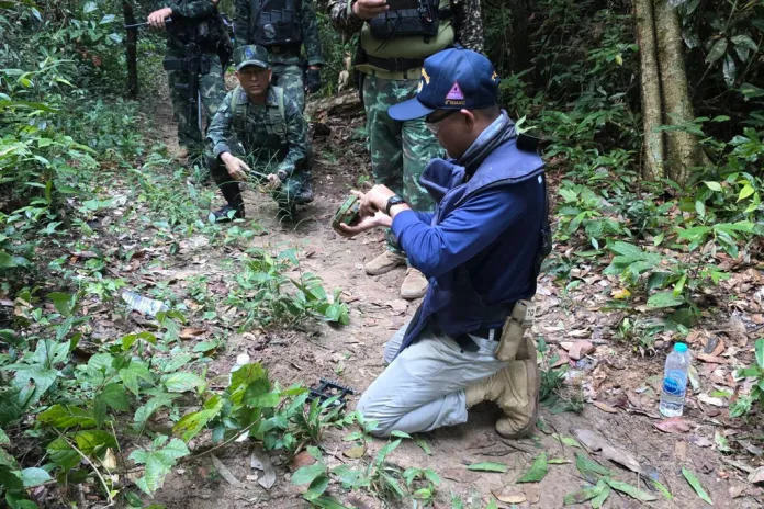 A Thai officer inspects a landmine.