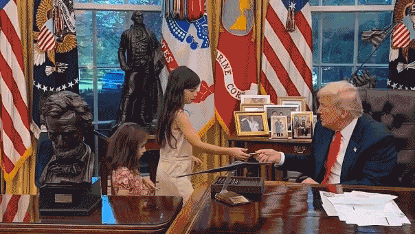 Children accept challenge coins from President Trump in the Oval Office.