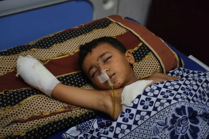 Yahya Shorbasi, who was injured by an unexploded ordnance, lies on a bed at Shifa Hospital.