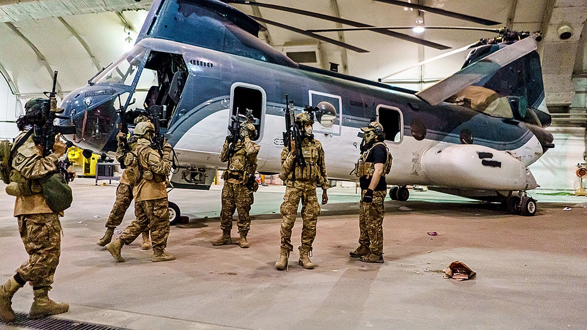 Taliban fighters stand near helicopter at Kabul International Airport