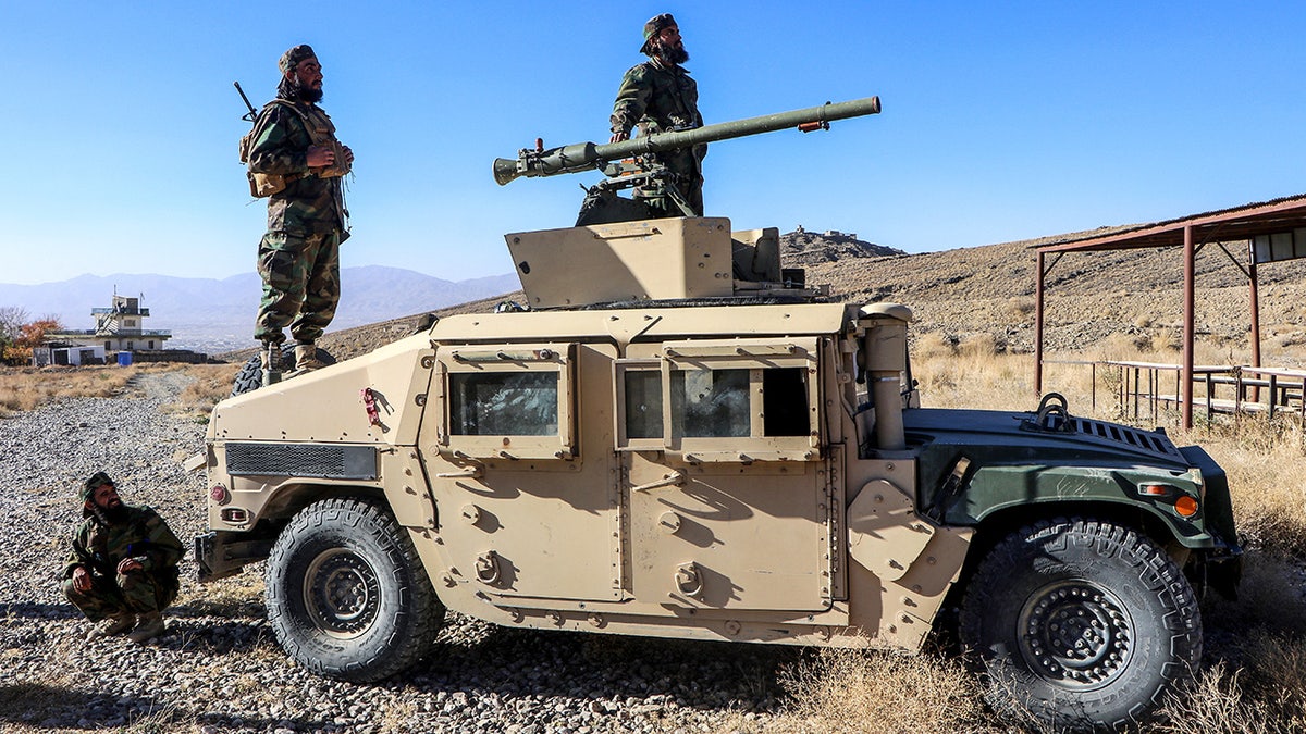 Afghan Taliban cadets stand on top of military vehicle