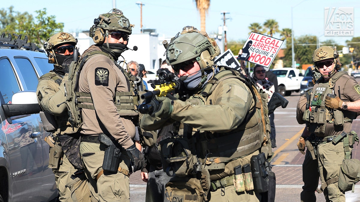 a federal agent readies a weapon