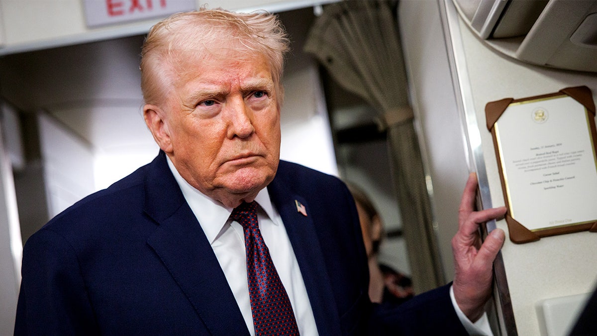 President Donald Trump speaks with reporters inside Air Force One during a flight.