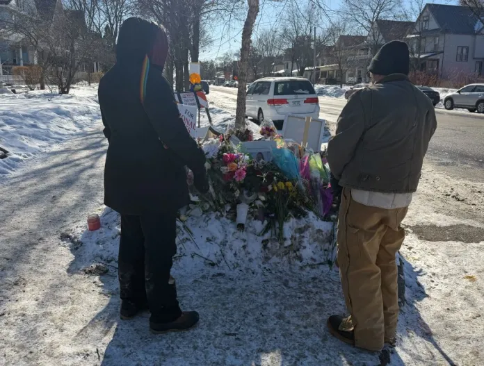 The Andersons, a middle-aged couple from a Minneapolis suburb, look at a tribute to Renee Nicole Good, who was fatally shot by federal law enforcement in January 2026. (Anna Giaritelli/Washington Examiner)