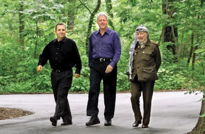From left, Israeli Prime Minister Ehud Barak, President Bill Clinton, and Palestinian leader Yasser Arafat take a break from negotiations to stroll the grounds of Camp David, Maryland, July 11, 2000. (Ron Edmonds/AP)