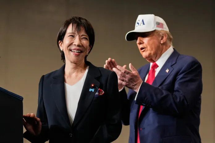 Japanese Prime Minister Sanae Takaichi, with President Donald Trump, reacts as she speaks to members of the military aboard the USS George Washington, an aircraft carrier docked at an American naval base in Yokosuka.