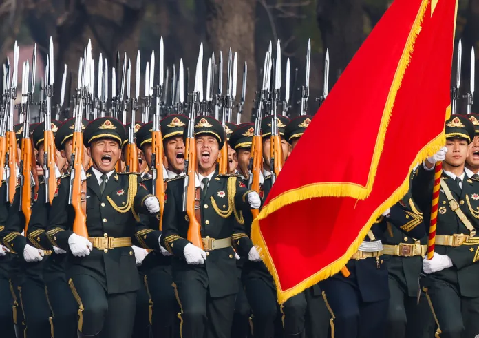 People's Liberation Army honor guard marches past the Great Hall of the People.