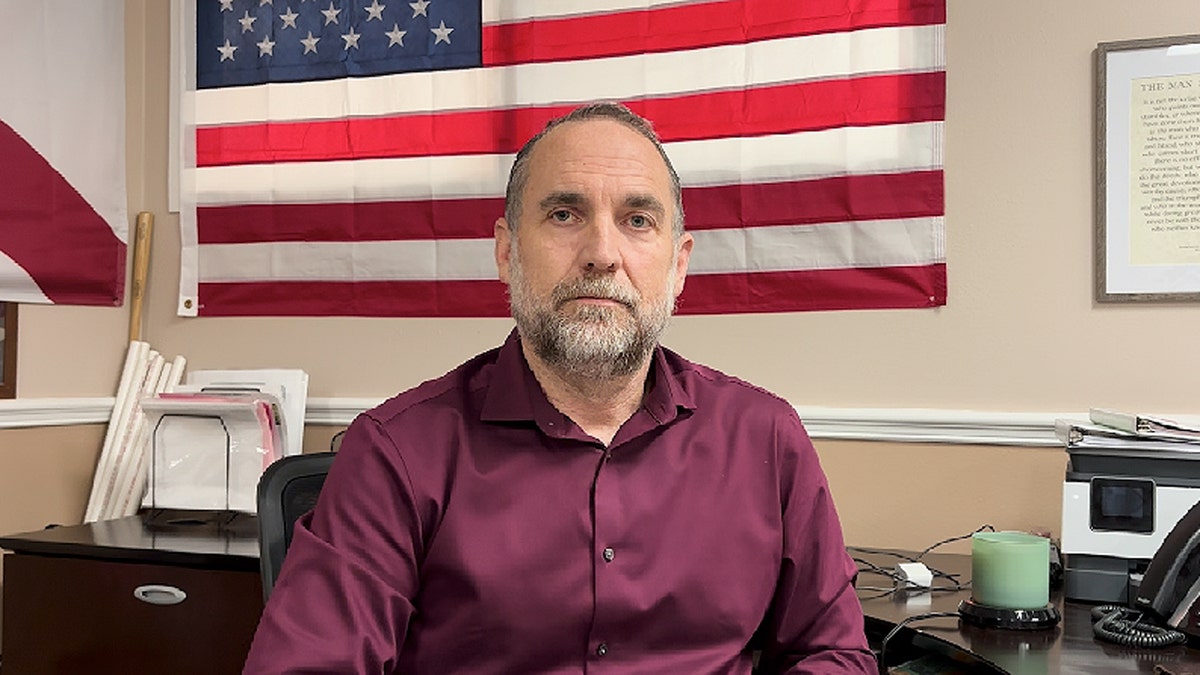 Eddie Speir sitting in front of an American flag
