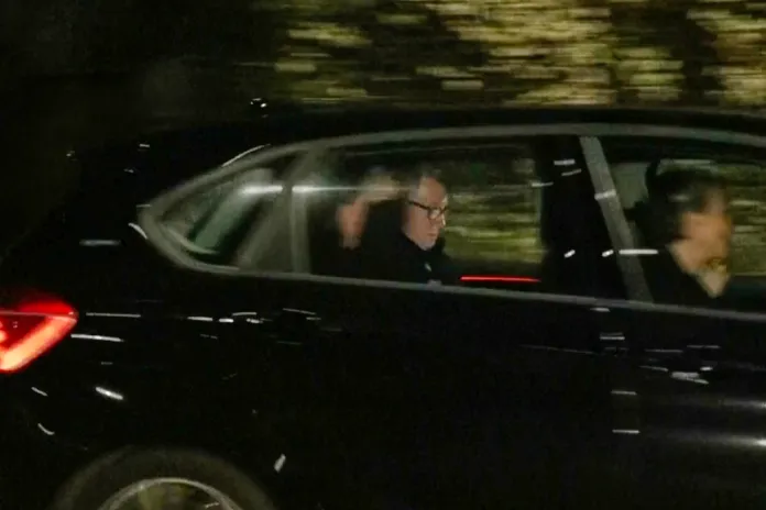 Mandelson is seen in the backseat of a car leaving a London police station