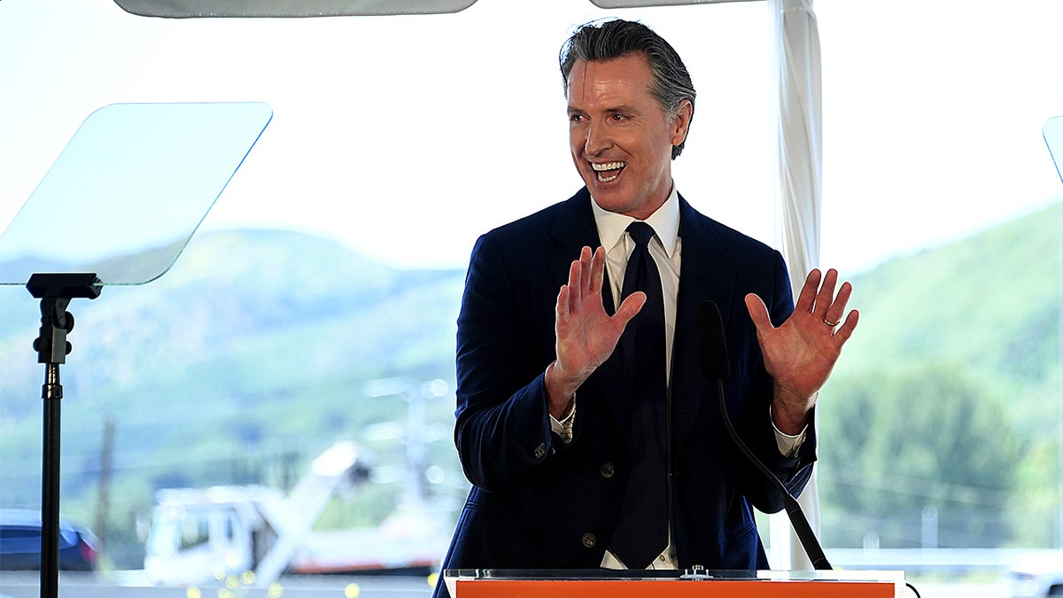 Gavin Newsom speaking at a podium outdoors during a groundbreaking ceremony in Agoura Hills, California.