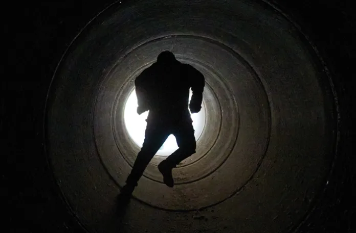 A boy runs inside a cement pipe serving as a bomb shelter while air raid sirens warn of incoming Iranian missiles in Michmoret, Israel, March 10, 2026. (Ariel Schalit/AP)