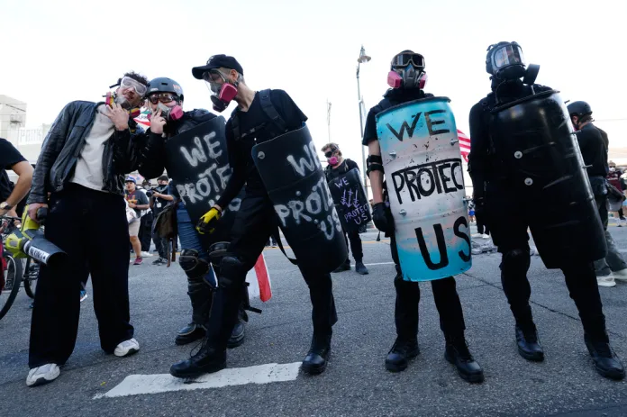 Protesters stand off against police outside the Metropolitan Detention Center in downtown Los Angeles during a "No Kings" rally Saturday, March 28, 2026.