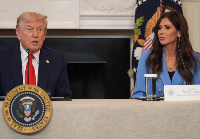 President Donald Trump speaks during a roundtable meeting on antifa in the State Dining Room at the White House, Wednesday, Oct. 8, 2025, in Washington, as Homeland Security Secretary Kristi Noem listens. (AP Photo/Evan Vucci)