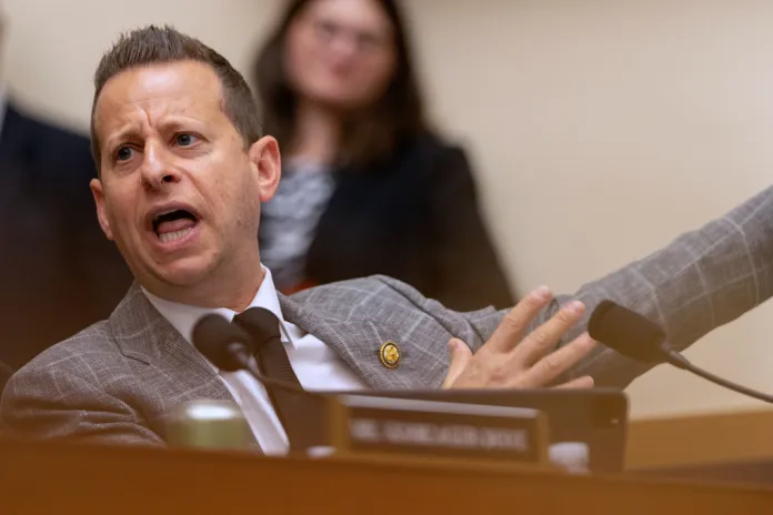Jared Moskowitz sits at a desk and speaks into microphone