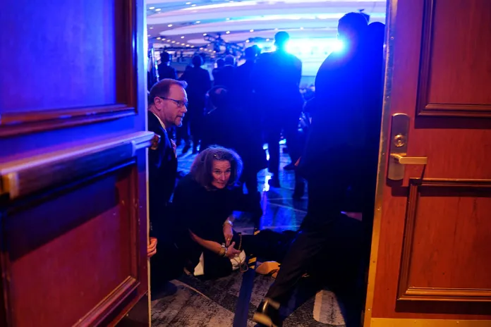 WASHINGTON, DC - APRIL 25: People take cover after an incident at the annual White House Correspondents Association Dinner April 25, 2026 in Washington, DC. According to reports, President Donald Trump, along with other government officials, were evacuated from the Washington Hilton after what sounded like gun fire. (Photo by Nathan Howard/Getty Images)