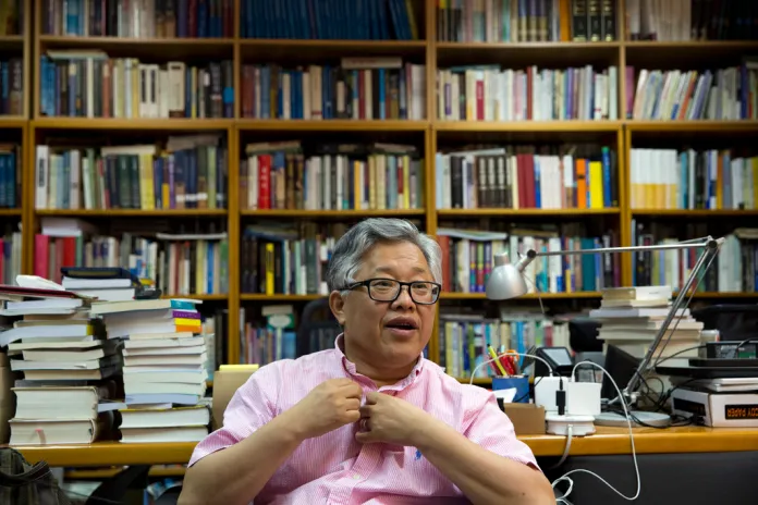Pastor "Ezra" Jin Mingri sits in front of a bookcase