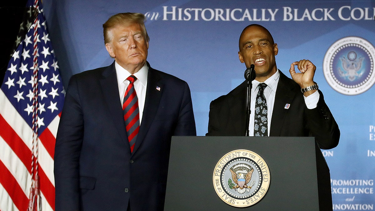 President Donald Trump standing next to HUD Secretary Scott Turner.