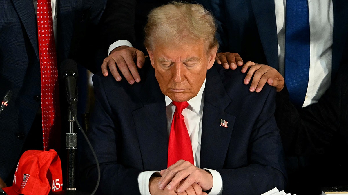 Former President Donald Trump praying during a roundtable discussion at Trump National Doral Miami resort