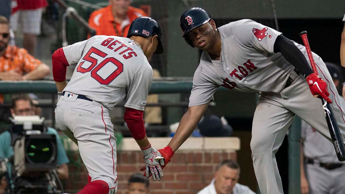 Mookie Betts and Rafael Devers celebrating on baseball field