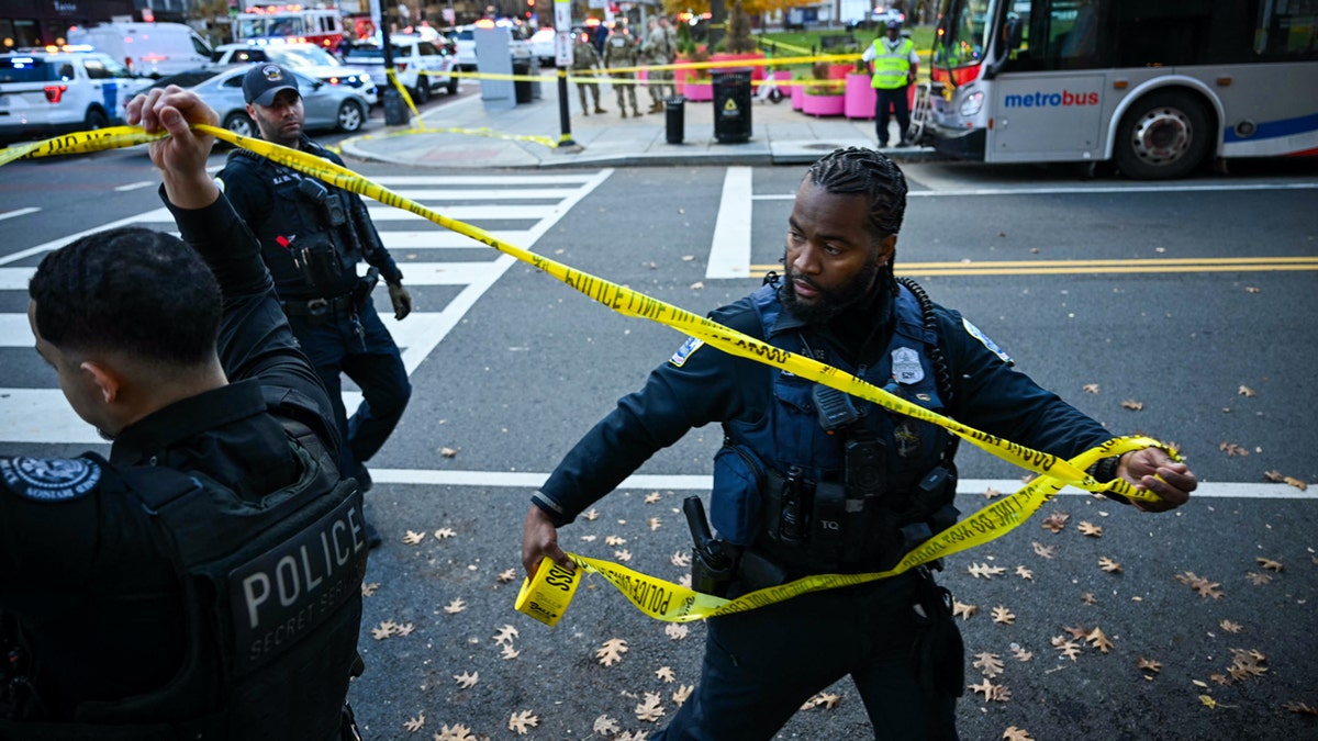 Police officers securing crime scene with tape in downtown Washington, D.C.