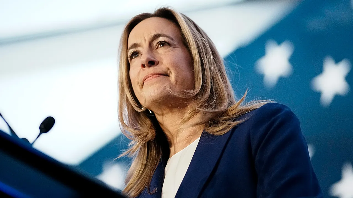 New Jersey Democrat Gov. Mikie Sherrill speaking at a podium with an American flag in the background.