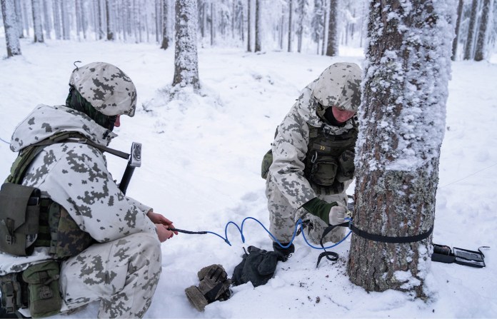 Finnish conscripts wearing winter camouflage practice installing anti-personnel mines in Kajaani, Finland, Feb. 3, 2026. (Alessandro RAMPAZZO / AFP / Getty Images)