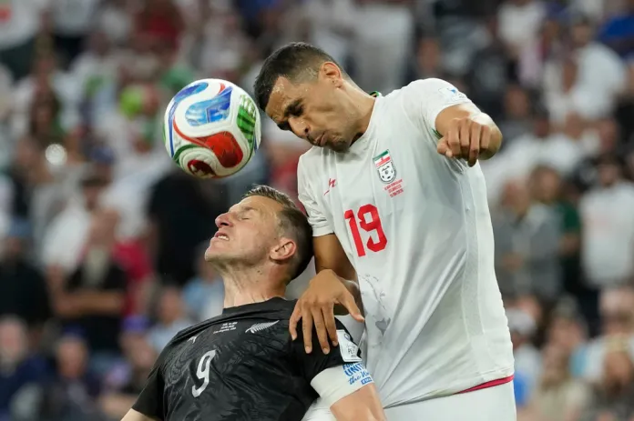 Iran's Ali Nemati (19) battles for the ball with New Zealand's Chris Wood (9) during the World Cup Group G soccer match between Iran and New Zealand in Inglewood, Calif., near Los Angeles, Monday, June 15, 2026.