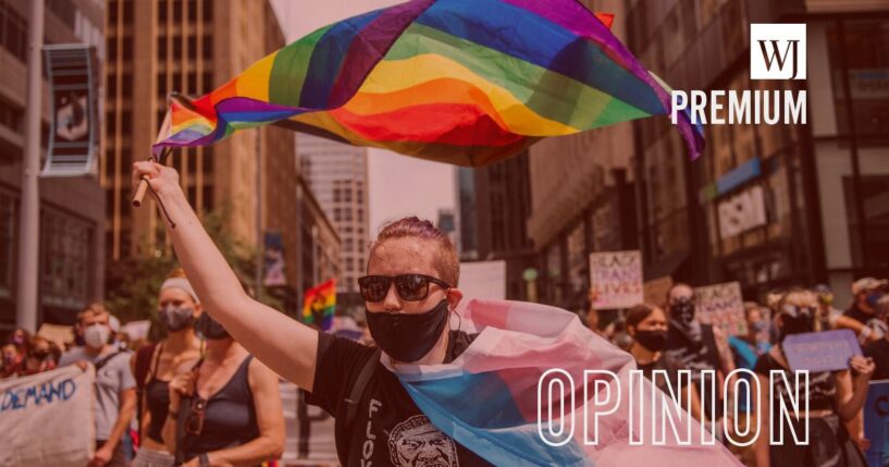 A mask-compliant protester waves flags in the air during a "pride" march on June 28, 2020, in Minneapolis, Minnesota.