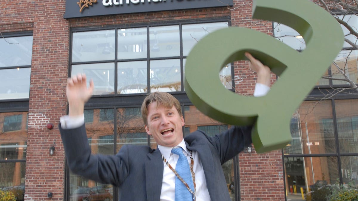Jonathan J. Bush Jr. smiling and gesturing inside athenahealth office in Watertown Massachusetts