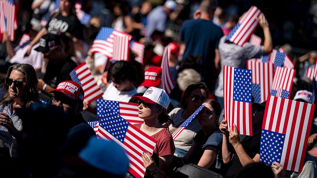 Attendees holding American flag posters at the Great American State Fair kickoff on the National Mall in Washington, D.C.