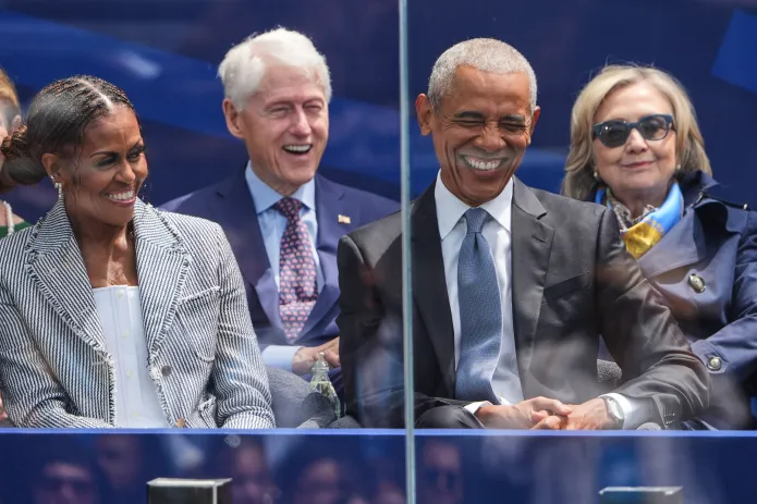Former President Barack Obama, right, shares a laugh with former first lady Michelle Obama, left, on stage during the dedication ceremony