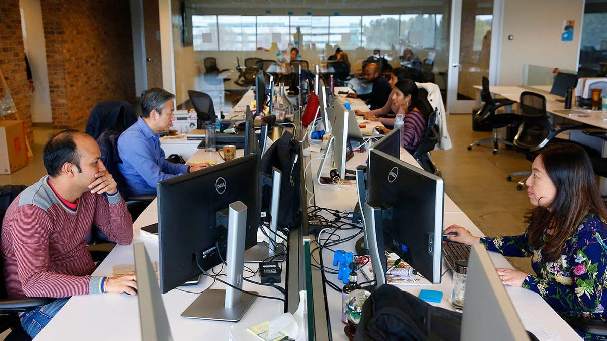 Engineers work at computer stations in an office.