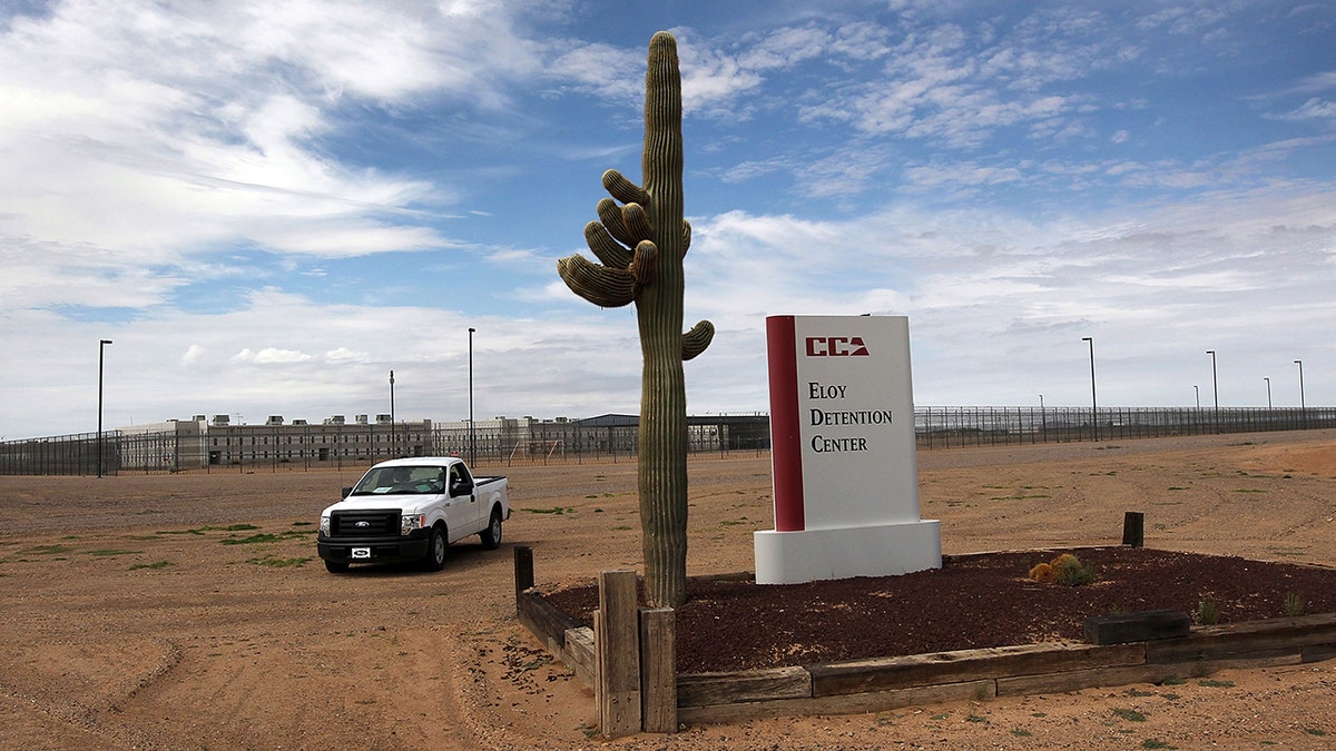 A cactus and sign mark the entrance to the Eloy Detention Facility