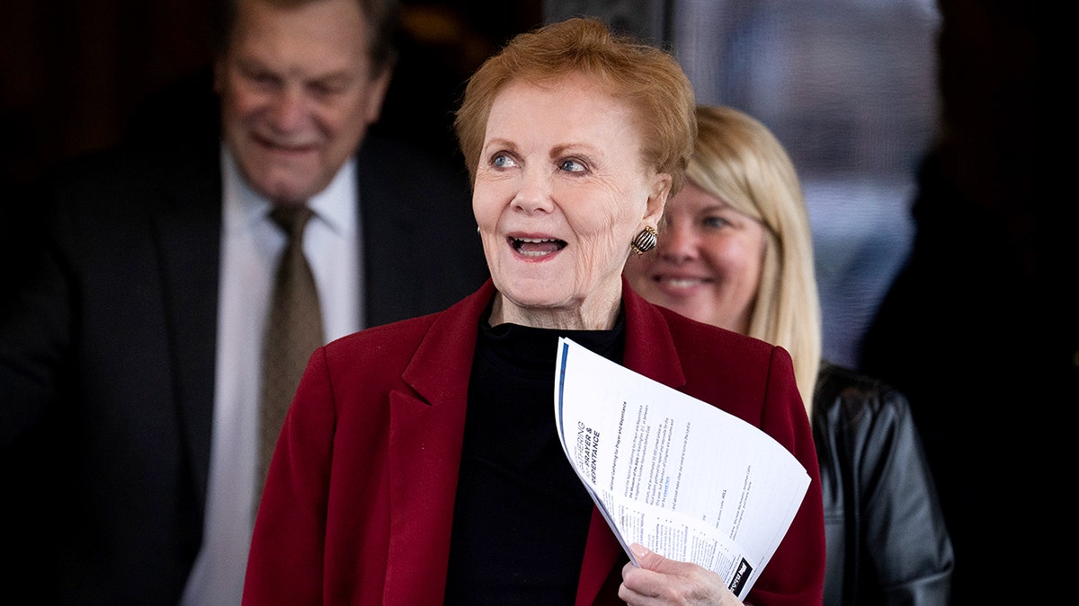 Kay Granger holds a paper up to her chest as she walks.