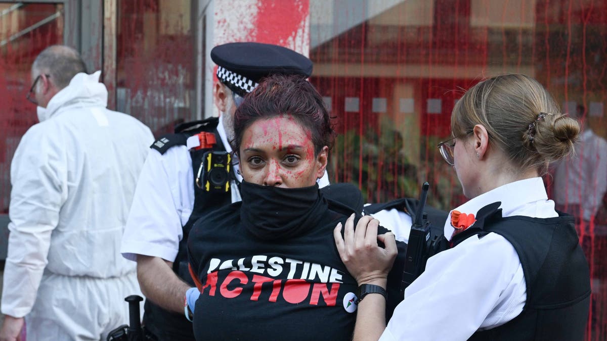 Police detain activists outside APCO Worldwide offices in London.