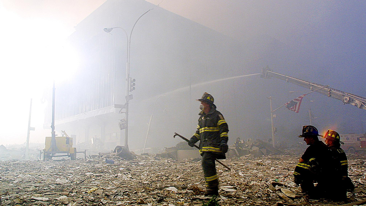 Firefighters walk through 9/11 rubble