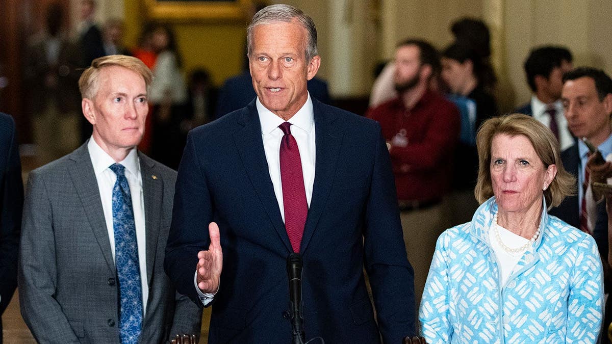 Senate Majority Leader John Thune speaking at a press conference flanked by Sen. James Lankford and Sen. Shelley Moore Capito