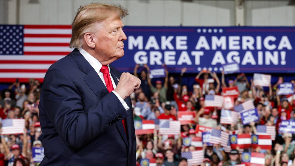 Donald Trump speaks at a podium on stage during a rally in Perry, Georgia.